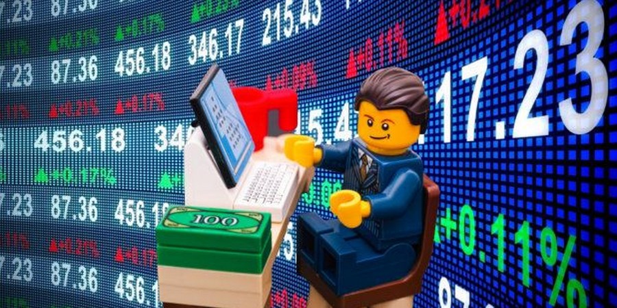 un bonhomme lego en trader de la& bourse pour illustrer l'investissement dans les lego